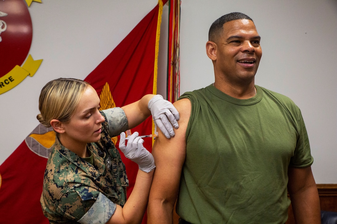 A Marine smiles as he gets vaccinated.
