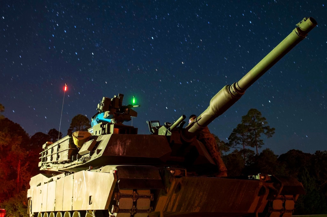 An Abrams tank waits in line at night during an exercise.