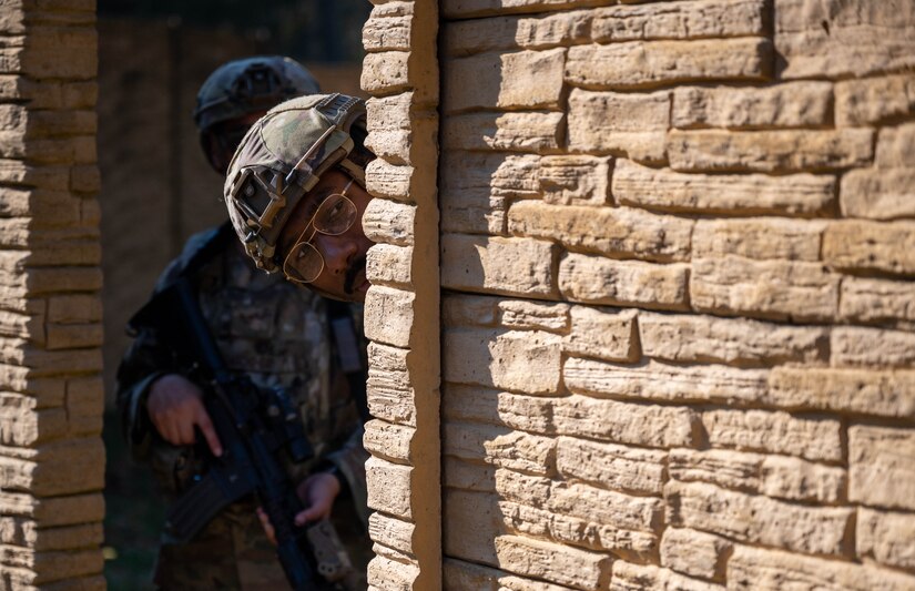U.S. Air Force Senior Airman Kiyon Robinson, 633d Security Forces Squadron base defense operations center controller, peers around the wall to check for any threats during an exercise at Joint Base Langley-Eustis, Virginia, Nov. 1, 2022.