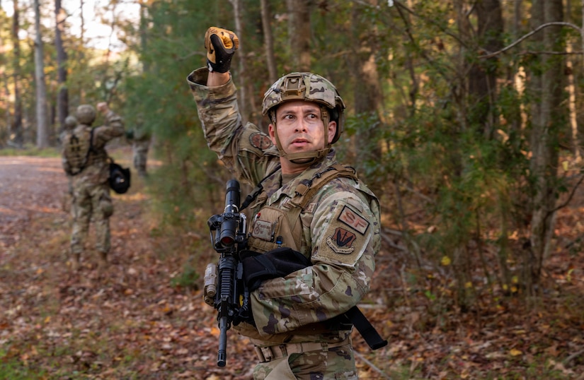 U.S. Air Force Tech. Sgt. Marcus Bernard, 633d Security Forces Squadron flight sergeant, signals his team to halt during a patrol in a field exercise at Joint Base Langley-Eustis, Virginia, Nov. 1, 2022.