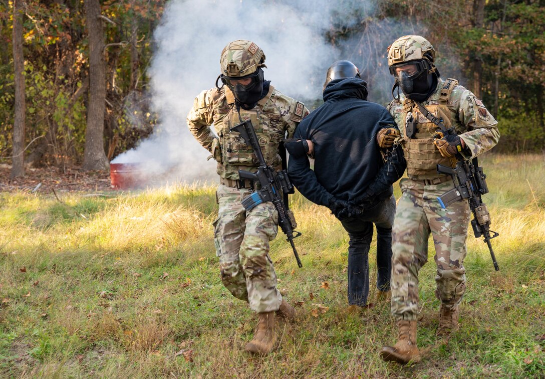 U.S. Air Force Senior Airman Tyler Zimbro, response force leader (left), and Tech. Sgt. Marcus Bernard, flight sergeant, both with 633d Security Forces Squadron, detain an assailant during the SF field exercise at Joint Base Langley-Eustis, Virginia, Nov. 1, 2022.