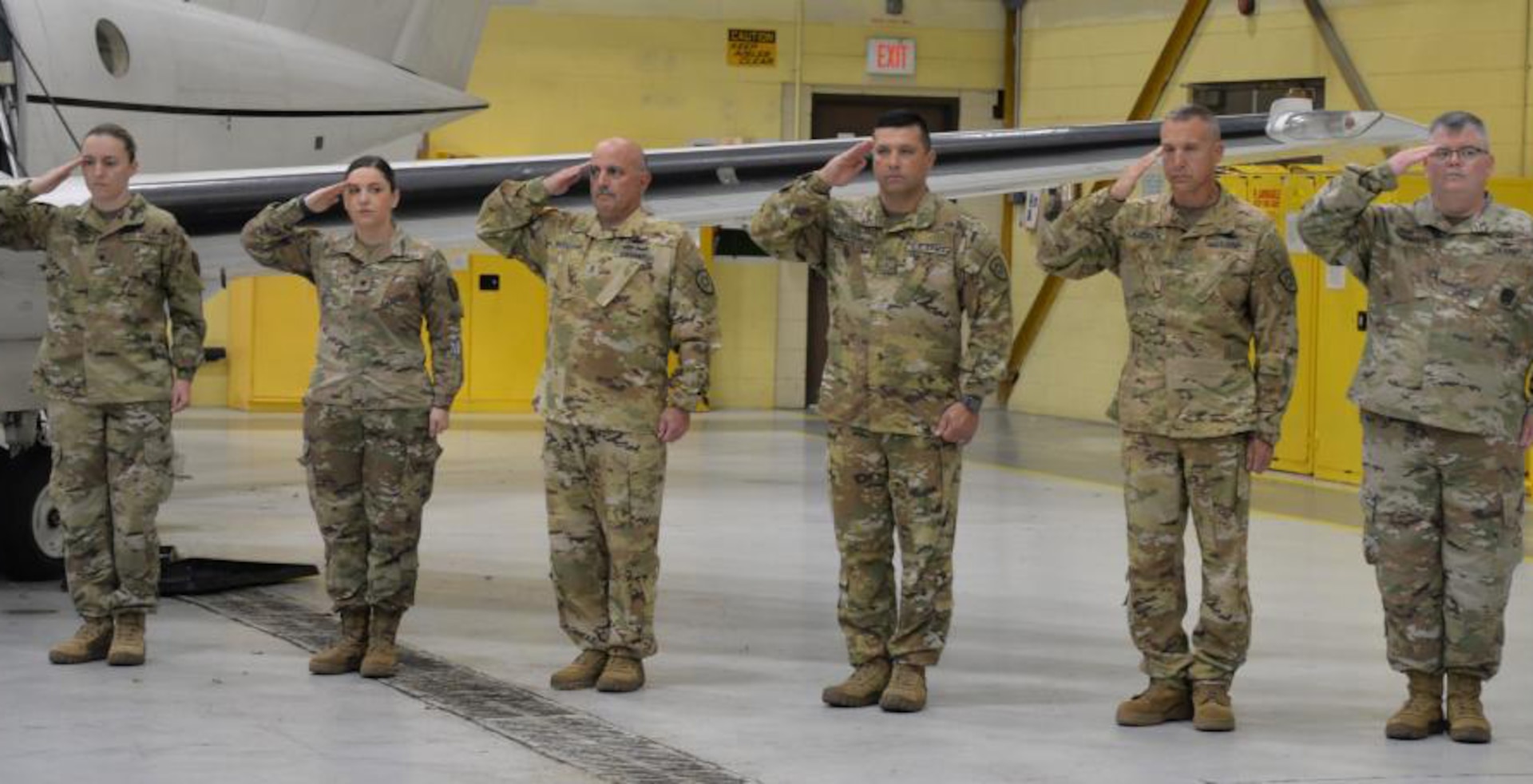 Six New York Army National Guard Soldiers assigned to Detachment 5 of Company C, 2nd Battalion, 245th Aviation Regiment, salute during the playing of the national anthem at a farewell ceremony at Army Aviation Support Facility #3 in Latham, New York, Nov. 6, 2022. The Soldiers, who fly the C-12 Huron transport aircraft, will deploy to Djibouti in East Africa to support U.S. military forces in the region.