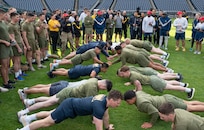 Service members from around the National Capital Region participate in a push-up competition hosted by the Washington Nationals baseball team on Oct. 28, 2022, at Nationals Park in Washington, D.C. Participants competed to complete as many push-ups as possible to ultimately win club-level tickets to a future game. (U.S. Air Force photo by Jason Treffry)