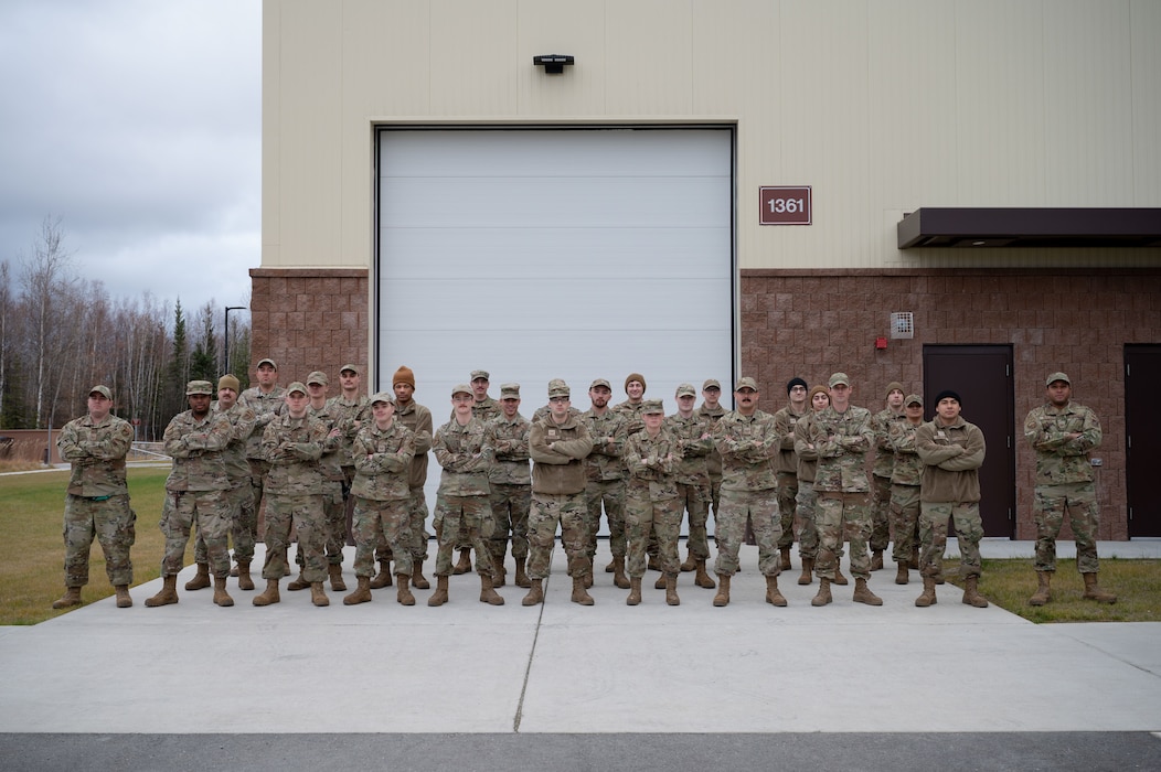 U.S. Air Force Airmen assigned to the 354th Aircraft Maintenance Squadron, Low Observable section, pose for a photo outside their building at Eielson Air Force Base, Alaska, October 10, 2022.