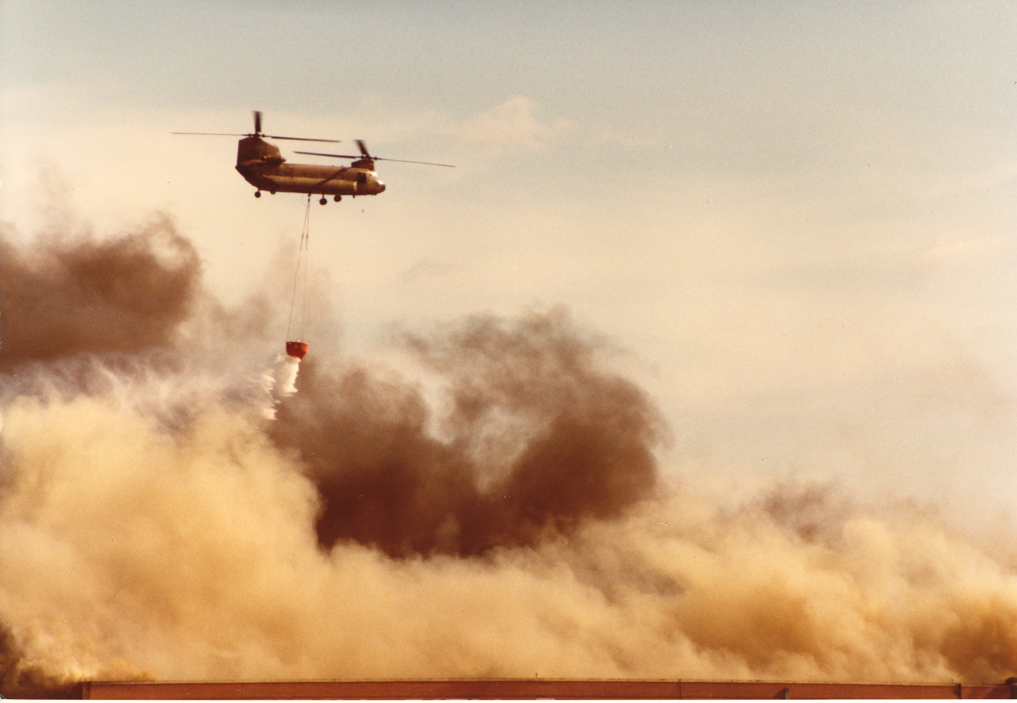 Helicopter dumping water on smoky Bld 3001 roof-1984 Fire
