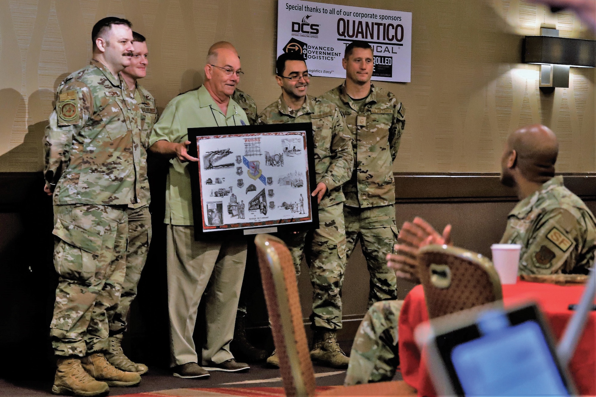Retired Master Sgt. Jim Saulnier, president of the Air Force Security Forces Association, presents a historical artwork print to defenders from the 445th Security Forces Squadron in recognition of their contributions in supporting the AFSFA’s national meeting, held in Dayton, Ohio, Sept. 21-25, 2022.