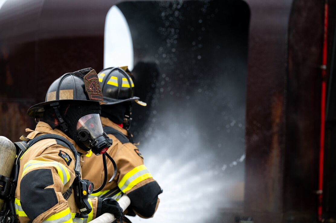 Members of the Naval District Washington Fire and Emergency Services extinguish a simulated aircraft fire onboard Joint Base Anacostia-Bolling.