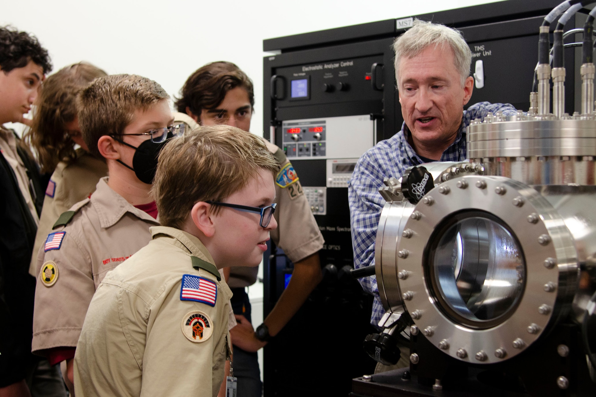 Lawrence Wolfe, a chemist at the Air Force Technical Applications Center, Patrick Space Force Base, Fla., explains how a mass spectrometer operates to Matthew Beckman and members of his troop during their visit to the nuclear treaty monitoring center Oct. 22, 2022.  Wolfe and other members of AFTAC volunteered their time to help the scouts earn the Nuclear Science Merit Badge.  (U.S. Air Force photo by Susan A. Romano)