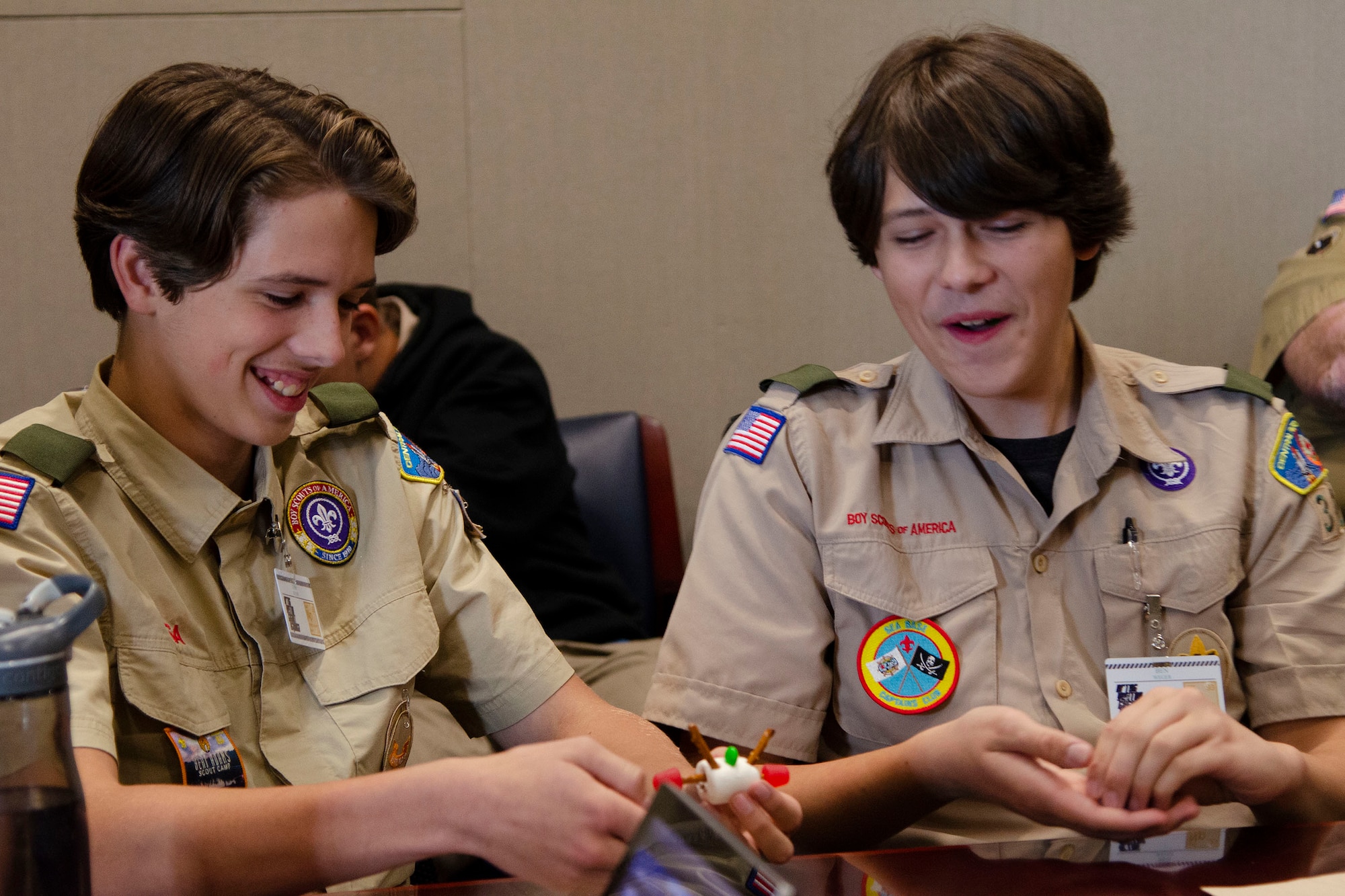 Josh Weger (left), and his older brother, Ben, create a 3-D model of a hydrogen atom using pretzel sticks, marshmallows and gum drops as part of the process to earn their Nuclear Science Merit Badge with the help from Airmen at Patrick Space Force Base, Fla.  The Wegers were among 60 other scouts who converged on the Air Force Technical Applications Center Oct. 22, 2022 to learn how the center executes its nuclear treaty monitoring mission from professionals in the field.  (U.S. Air Force photo by Susan A. Romano)