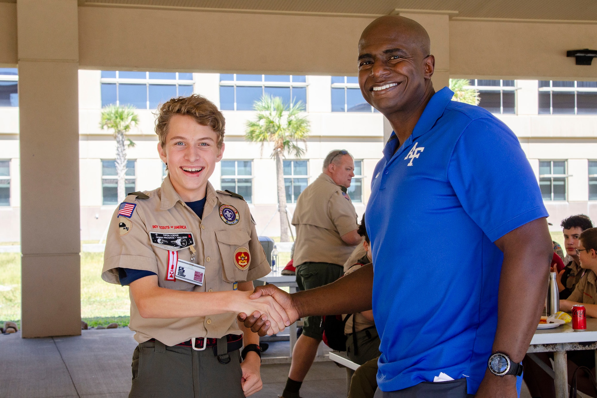 Liam Walders, a 10th grader at Holy Trinity Episcopal Academy in Melbourne, Fla., shakes hands with Col. James A. Finlayson, commander of the Air Force Technical Applications Center, after the colonel presented his challenge coin to Walders Oct. 22, 2022.  Walders was at the base with 61 other Central Florida Boy Scouts to earn the Nuclear Science Merit Badge with the help of Airmen from the nuclear treaty monitoring center.  (U.S. Air Force photo by Susan A. Romano)