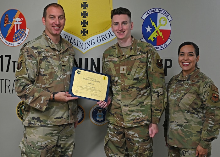 U.S. Air Force Col. Jason Kulchar, 17th Training Group commander, and Chief Master Sgt. Valerie Nededog, 17th TRG senior enlisted leader, present the student of the month award to 2nd Lt. Sean Brody, 315th Training Squadron student at Goodfellow Air Force Base, Texas, Nov. 7,  2022. Brody will graduate from Goodfellow as an intelligence officer serving in the Air Force. (U.S. Air Force photo by Senior Airman Michael Bowman)