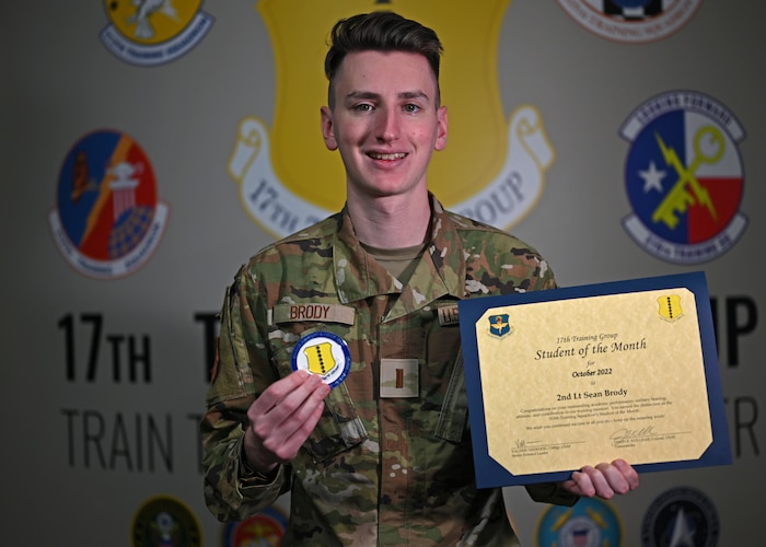 U.S. Air Force 2nd Lt. Sean Brody, 315th Training Squadron student, presents his certificate and coin at Goodfellow Air Force Base, Texas, Nov. 7, 2022. Brody’s peers and instructors voted for him to win Student of the Month for standing out among his classmates. (U.S. Air Force photo by Senior Airman Michael Bowman)