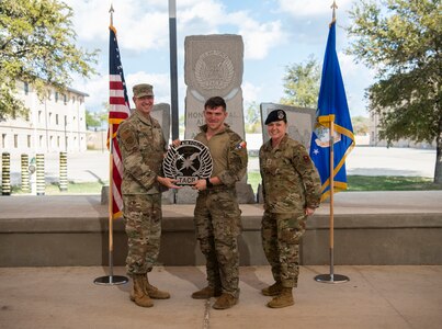 The winner of the best tactical air control party Airman of Lightning Challenge 2022, 1st Lt. Joseph Messare (center), 7th Air Support Operations Squadron, poses for a photo with Col. Nathan Colunga (left), Special Warfare Training Wing commander, and Command Chief Master Sgt. Tessa Fontaine (right), SWTW command chief (U.S. Air Force photo by Katherine Spessa).