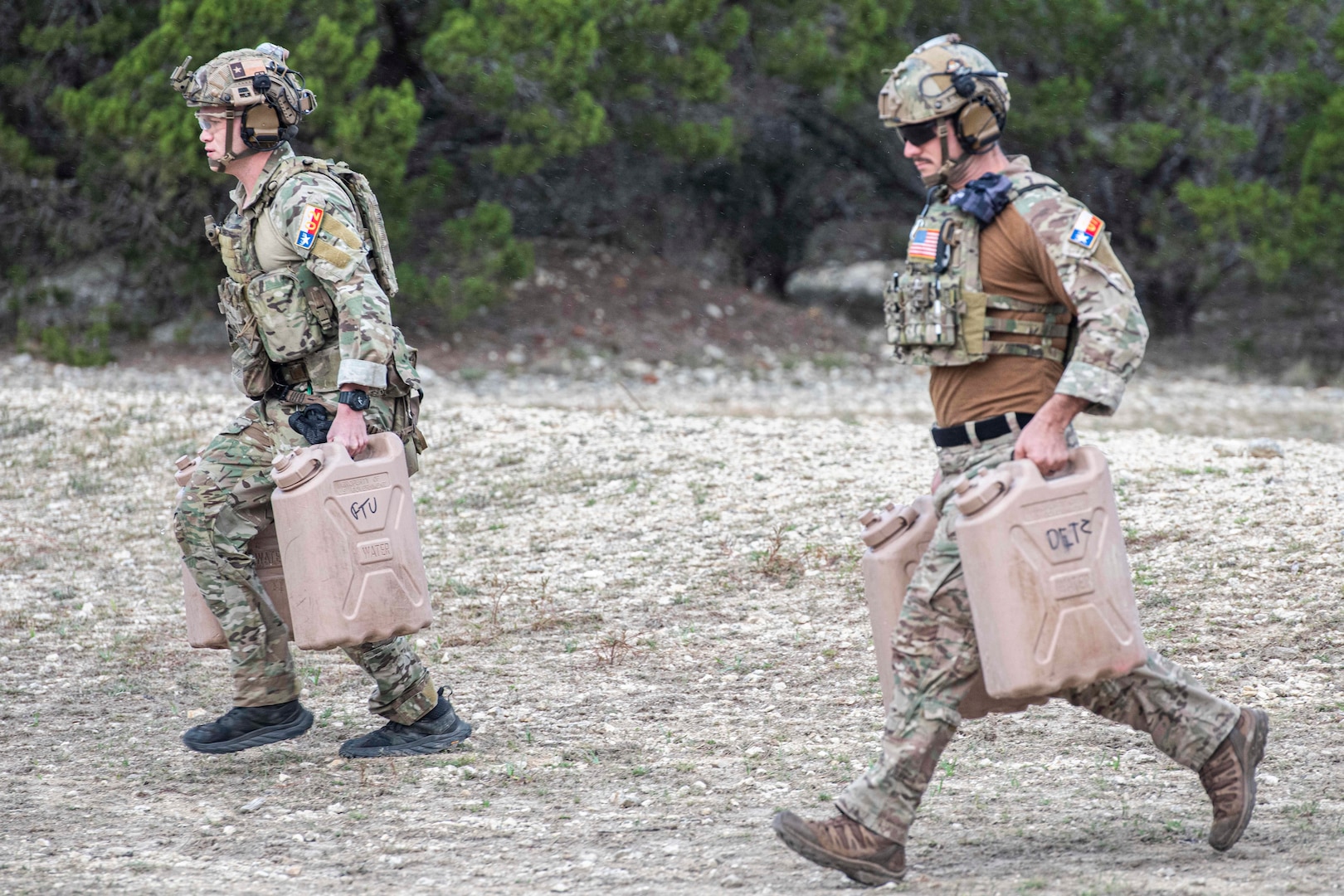 Two U.S. Air Force Tactical Air Control Party (TACP) specialist carry water canisters during the marksmanship portion of the TACP Lightning Challenge 2022, at Joint Base San Antonio-Camp Bullis, Texas, Nov. 4, 2022. Lightning Challenge tests United States Air Force TACP Airmen through competition in agile combat employment, physical ability and marksmanship in order to identify the most outstanding multi-capable Airman in the world, prepared to fight and win on the all-domain battlefields of the future. (U.S. Air Force photo by Tristin English
