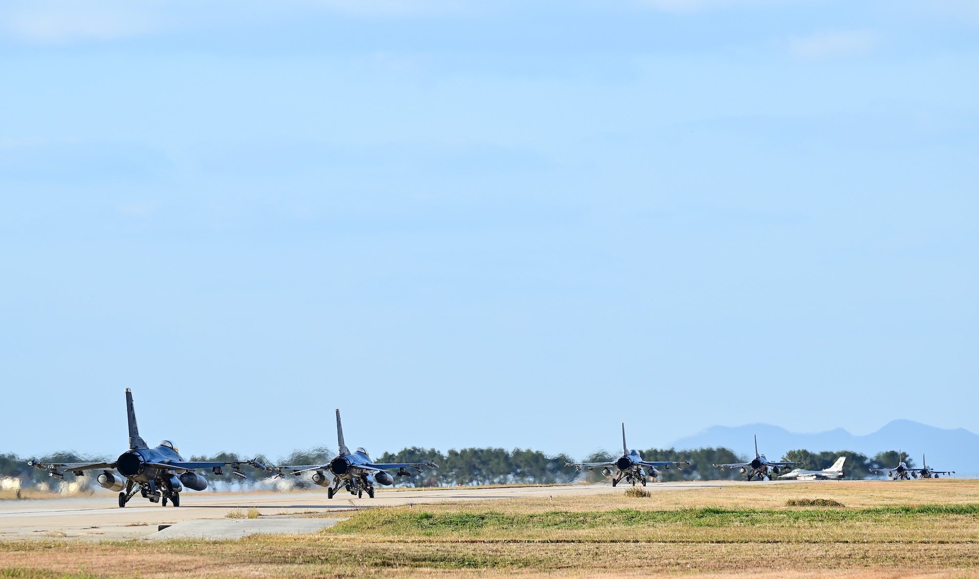 Seven F-16 Fighting Falcons with the 80th Fighter Squadron taxi at Kunsan Air Base, Republic of Korea, Nov. 4, 2022. Kunsan launched 16 jets as a part of a Pacific Air Forces annual command sponsored Combined Flying Training Event, VIGILANT STORM 23, showcasing their ability to be ready to fight tonight. The training event allowed fourth and fifth-generation fighters to practice offensive and defensive tactics. (U.S. Air Force photo by Staff Sgt. Sadie Colbert)