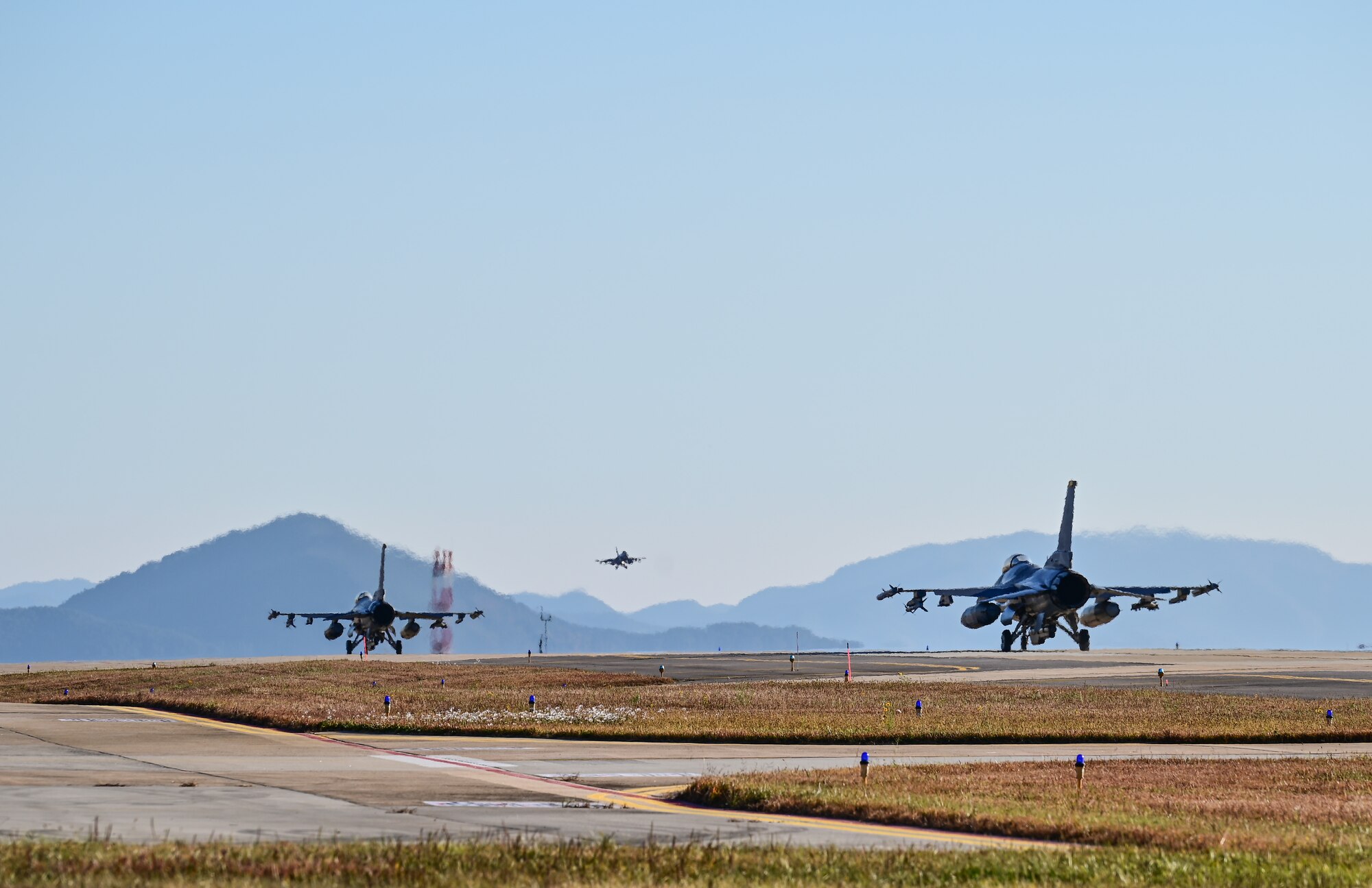 Two U.S. Air Force F-16 Fighting Falcons with the 80th Fighter Squadron taxis as a Republic of Korea Air Force (ROKAF) F-16 Fighting Falcon passes by during VIGILANT STORM 23 at Kunsan Air Base, Republic of Korea, Nov. 2, 2022. A main goal of the VIGILANT STORM 23 combined flying training event is to further improve interoperability between U.S. and ROK forces. (U.S. Air Force photo by Staff Sgt. Sadie Colbert)