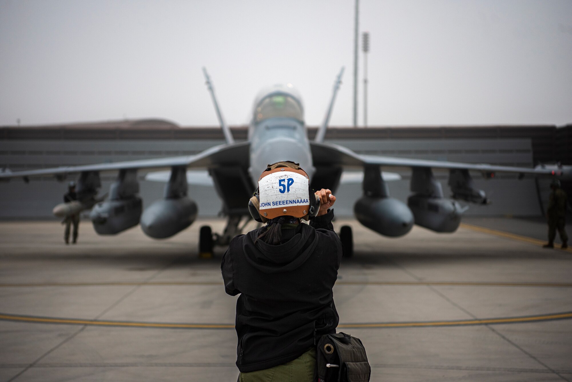 U.S. Navy Airman Seena Maharjan, plane captain assigned to Electronic Attack Squadron 131 at Naval Air Station Whidbey Island, Washington, signals an EA-18G Growler prior to flying sortie during Vigilant Storm 23 at Osan Air Base, Republic of Korea, Nov. 1, 2022.
