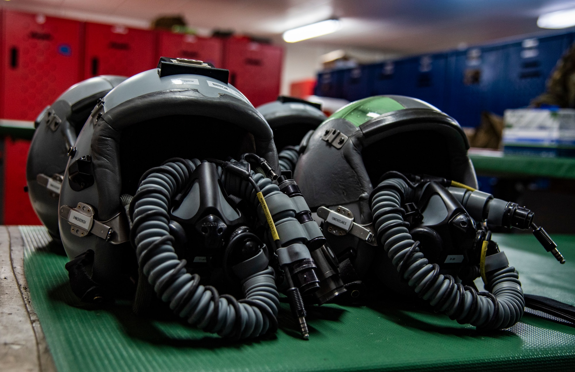 Four fighter pilot helmets on a table at the 332d Air Expeditionary Operations Support Squadron Aircrew Flight Equipment facility at an undisclosed location, Southwest Asia, Oct. 29, 2022. Aircrew Flight Equipment personnel perform maintenance and upkeep for all equipment that pilots and other aircrew need to perform flight missions. (U.S. Air Force photo by: Tech. Sgt. Jim Bentley)