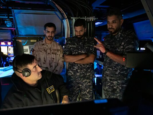 221105-N-UL352-1154 ARABIAN GULF (Nov. 5, 2022) Chief Electronics Technician Matthew Tackett, assigned to guided-missile destroyer USS Delbert D. Black (DDG 119), speaks with members of the United Arab Emirates armed forces and the Royal Bahrain Naval Force during exercise Nautical Defender in the Arabian Gulf, Nov. 5. The multilateral training event involved U.S. Naval Forces Central Command, Royal Saudi Navy’s Eastern Fleet and UK’s Royal Navy, with observers from several regional countries.