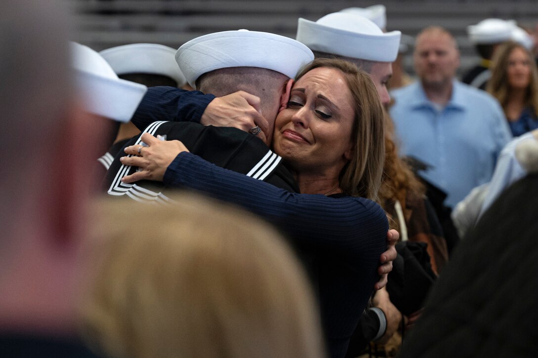 A woman embraces a sailor.