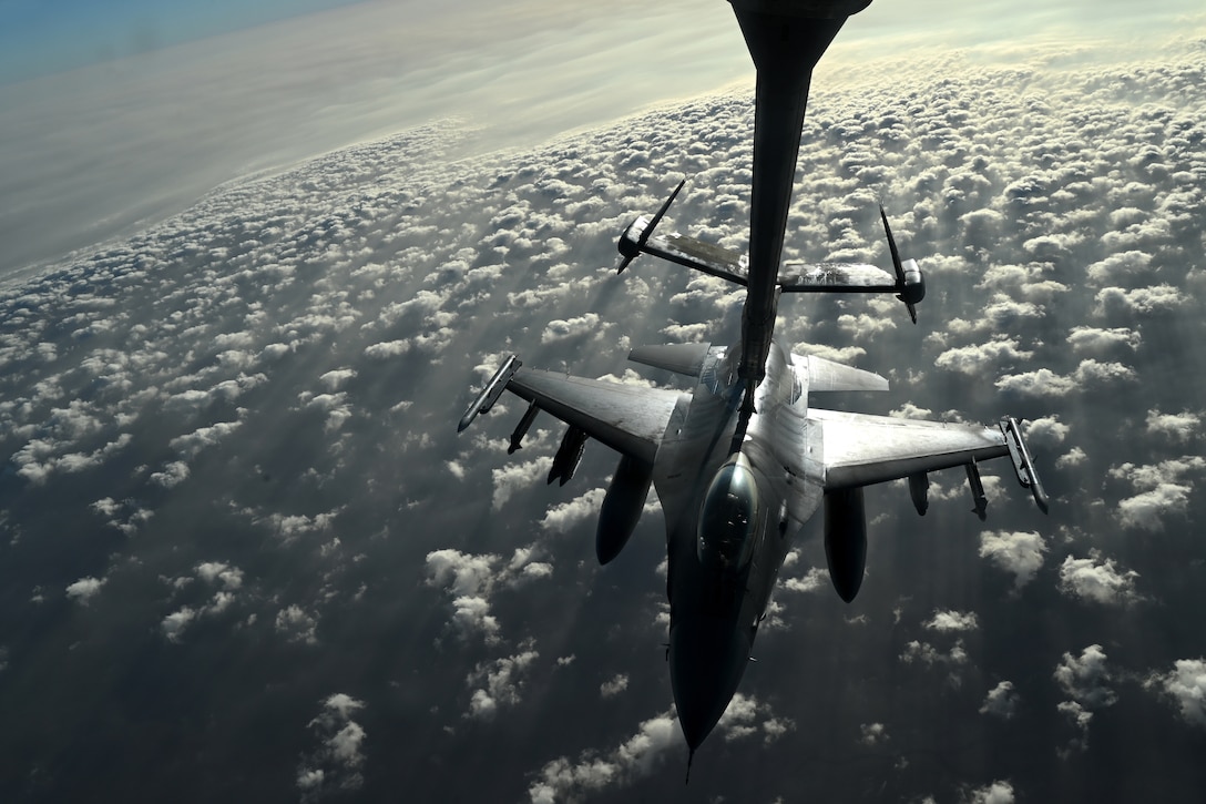 A fighter jet is refueled in midair.