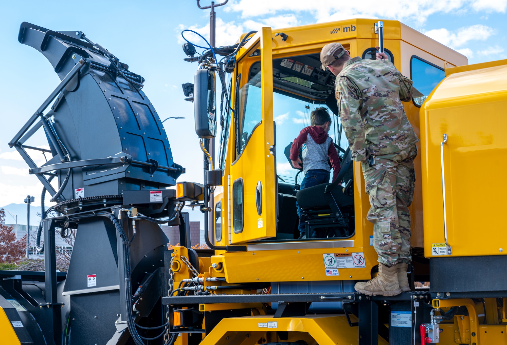 Military member and child on snowplow