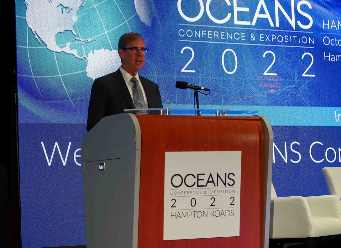 Dr. Peter Adair, Naval Surface Warfare Center Panama City Division technical director, addresses the in-person and virtual audience as a keynote speaker during one of the plenary sessions at OCEANS 2022 Hampton Roads in Virginia Beach, Va., Oct. 19. OCEANS is the premier marine technology and ocean engineering conference and Adair shared NSWC PCD’s role and how Panama City hosted the very first OCEANS conference in 1970. (U.S. Navy photo by Jeremy Roman)