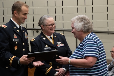 Maj. Elaine Nussbaum and Col. Kevin Little present a certificate of appreciation to Nussbaum’s mother, Therese, during Nussbaum’s Nov. 4 retirement ceremony at Illinois National Guard headquarters on Camp Lincoln, Springfield. Nussbaum, was a key leader in the famed Paris, Ill.-based 1544th Transportation Company and took care of her Soldiers for 22 years. (U.S. Army photo by Spc. Justin Malone, Illinois National Guard)