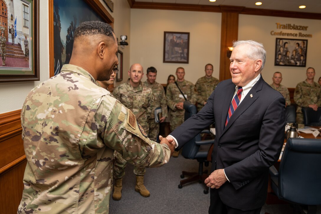 Secretary of the Air Force Frank Kendall presents a coin to an Airman.