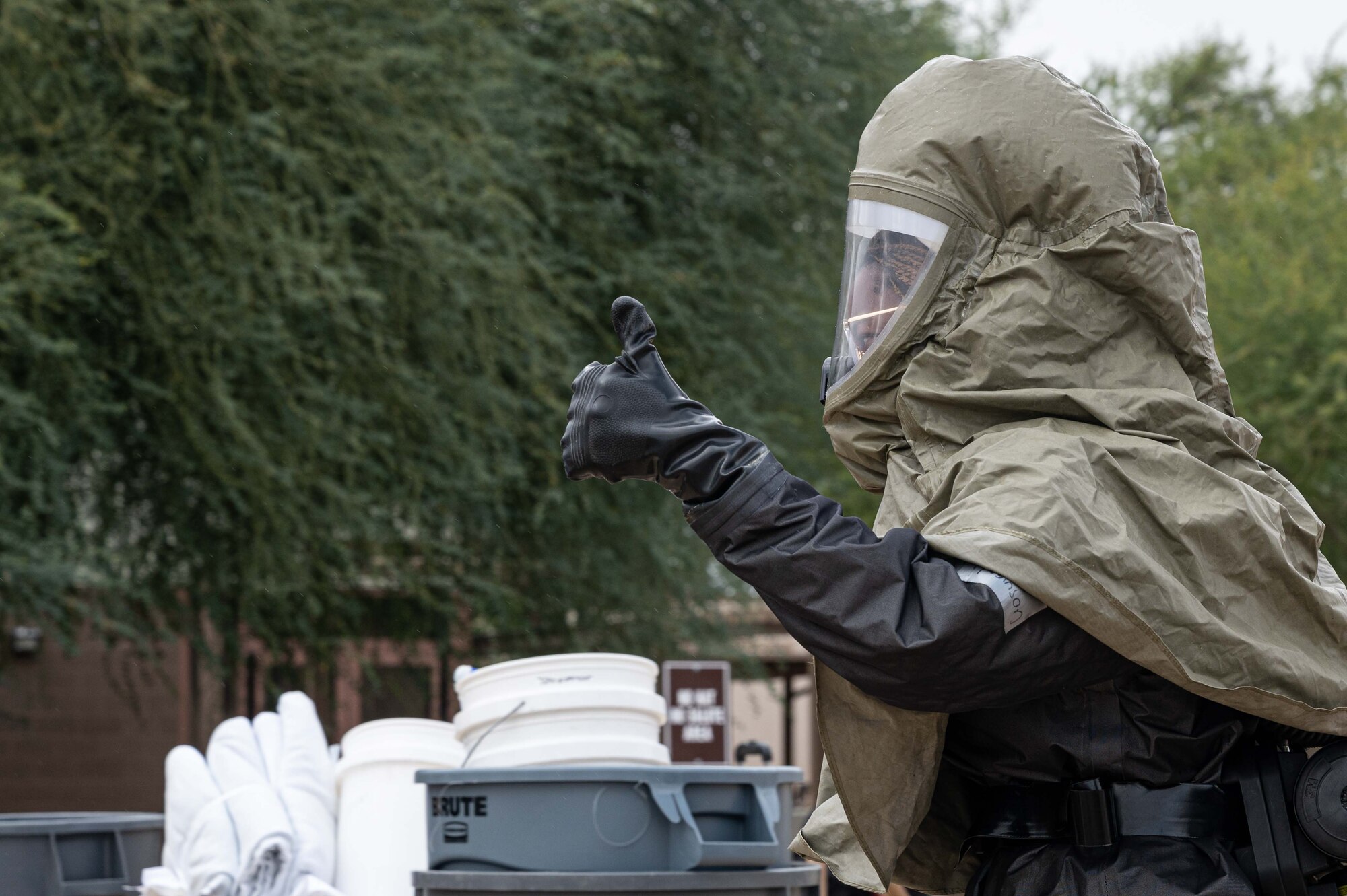 Pictured above is a person in a hazmat suit giving thumbs up.