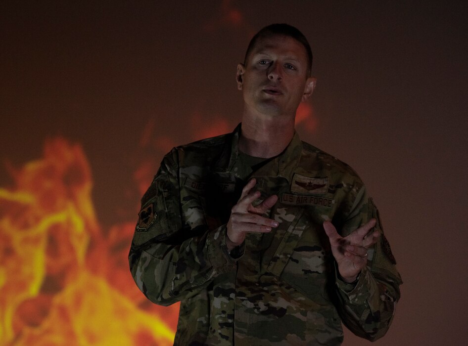 An Airman speaks on a stage.