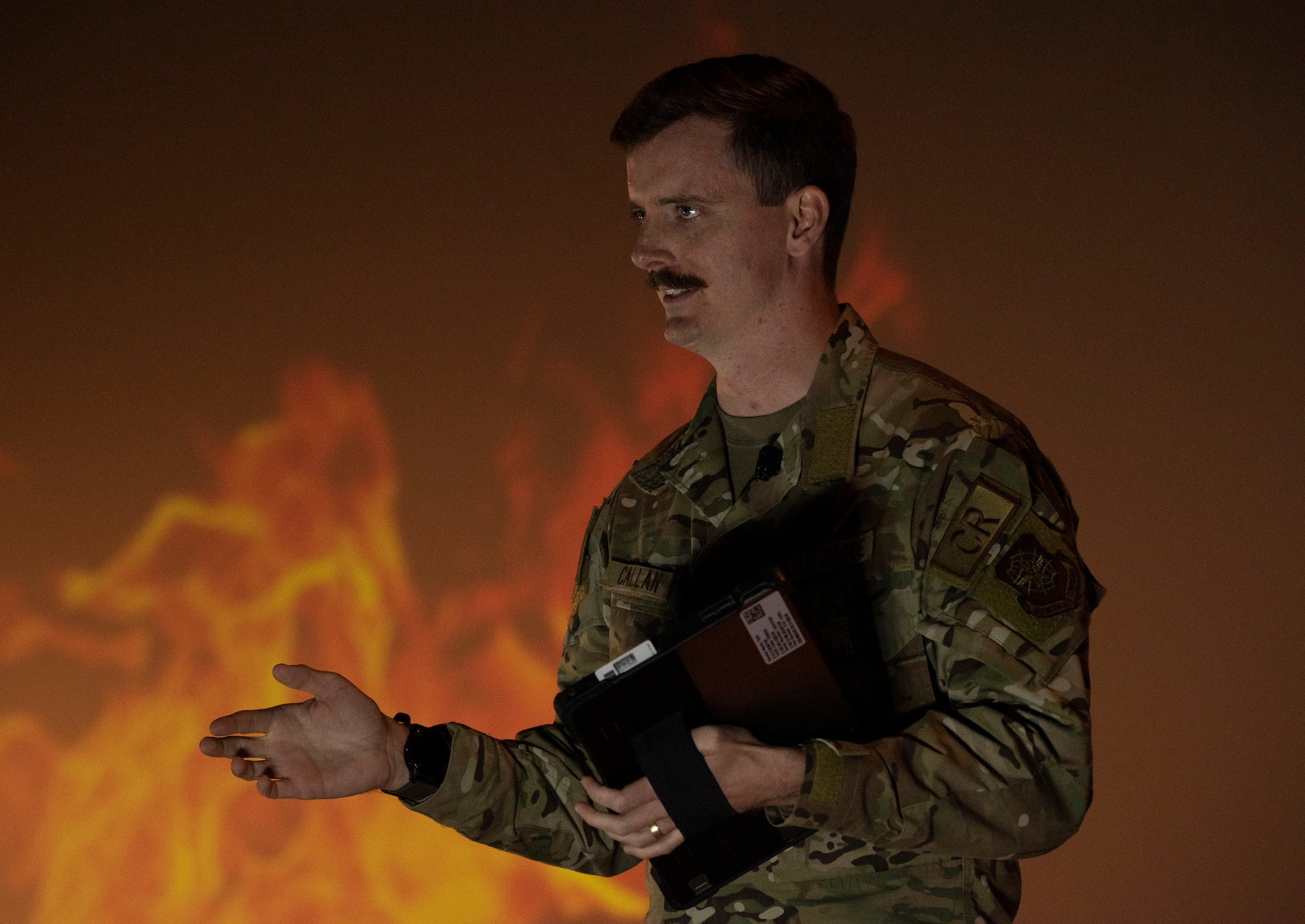 An Airman speaks on a stage.
