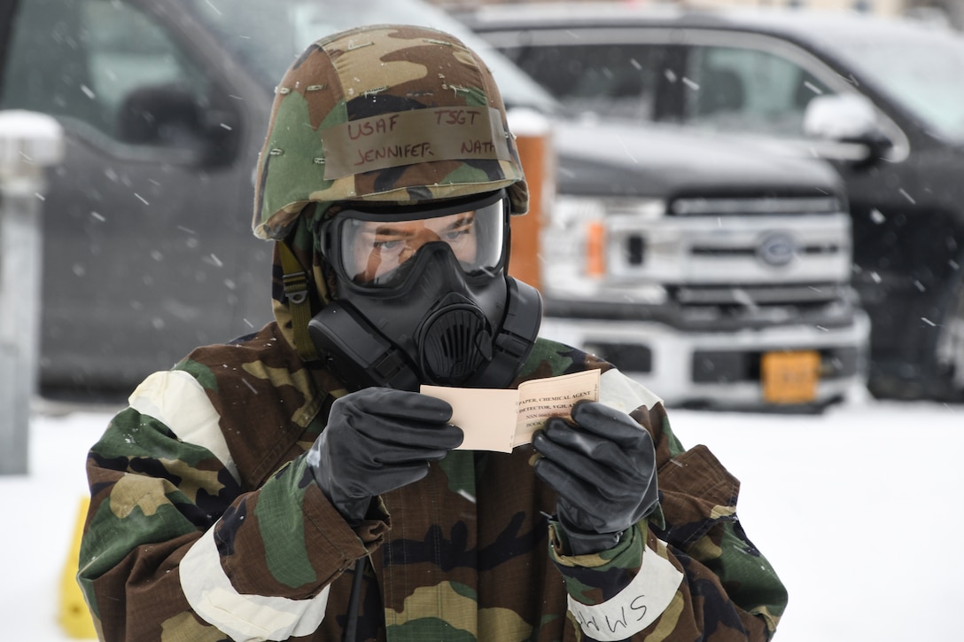 Tech. Sgt. Jennifer Nath of the 168th Wing Force Support Squadron simulates inspecting M8 paper and reporting observations in a CBRN environment at Eielson Air Force Base, Alaska, Nov. 4, 2022. Nath was part of a post-attack reconnaissance team during Golden Raven 23-1 at Eielson Air Force Base. Team Eielson exercised the capability to accomplish the mission while countering CBRN threats. (U.S. Air National Guard photo by Senior Master Sgt. Julie Avey)