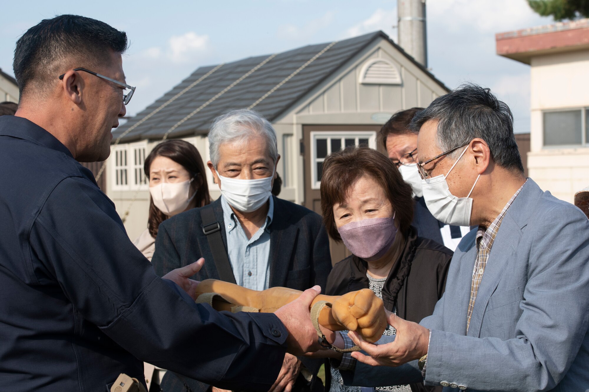 Naokazu Tajika, 374th Security Forces Squadron military working dog trainer, shows members of the Akishima-Yokota Friendship Club a rubber arm used for K9 decoy training during a base immersion tour hosted by the 374th Mission Support Group at Yokota Air Base, Japan, Nov. 4, 2022.
