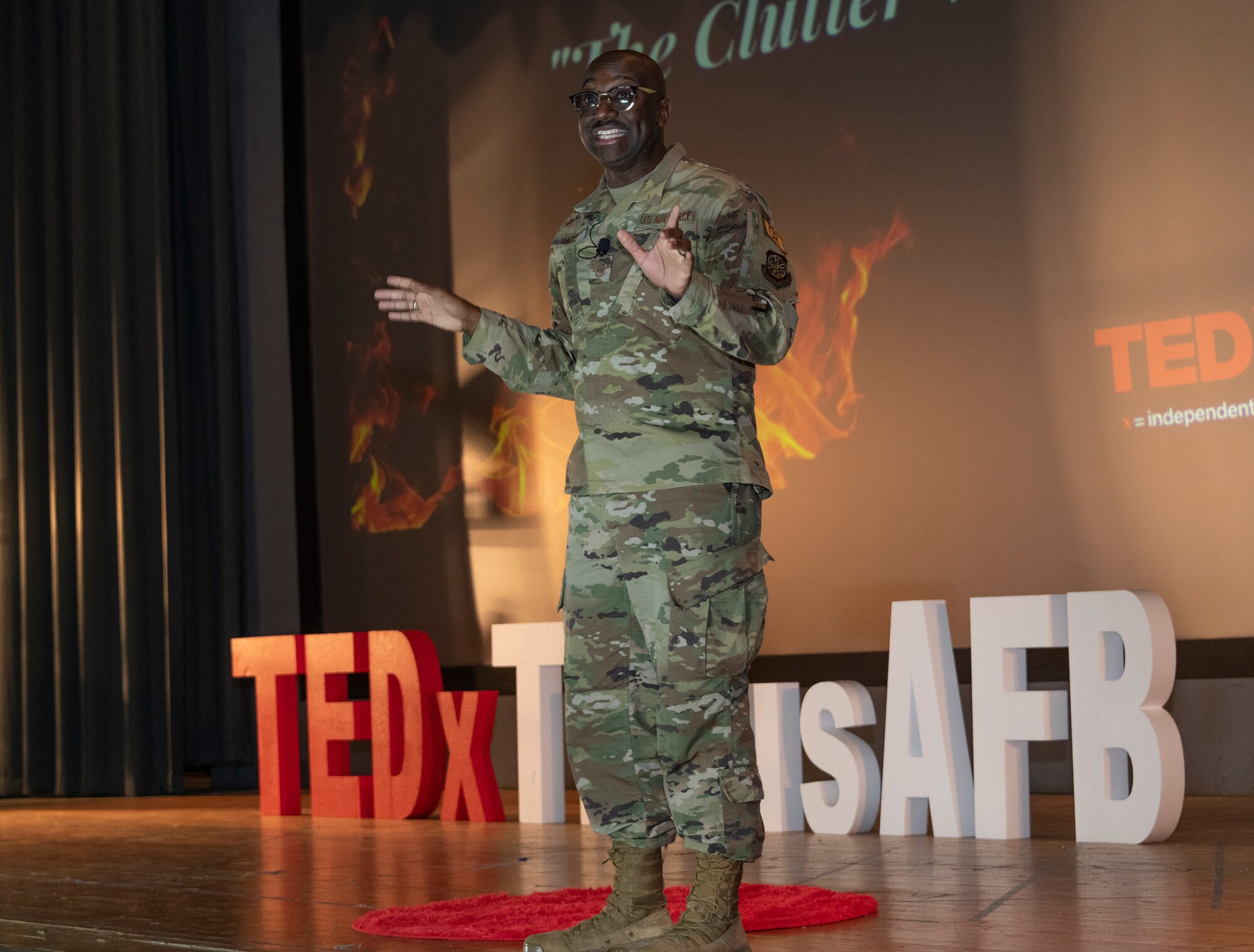 An Airman speaks on a stage.