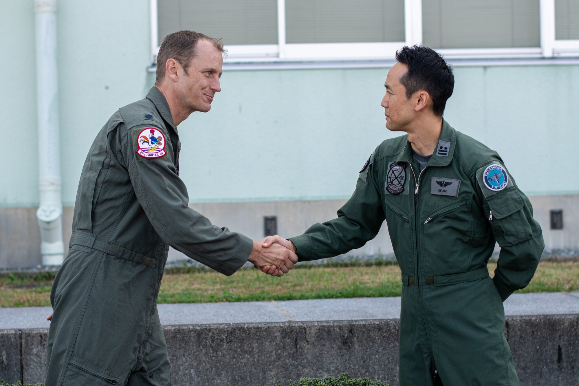 U.S. and Japanese commanders shake hands.