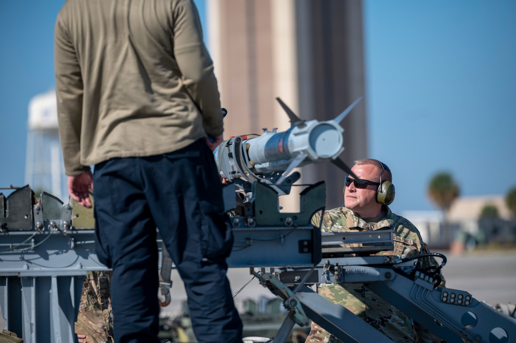 Airmen secure missiles to a cart