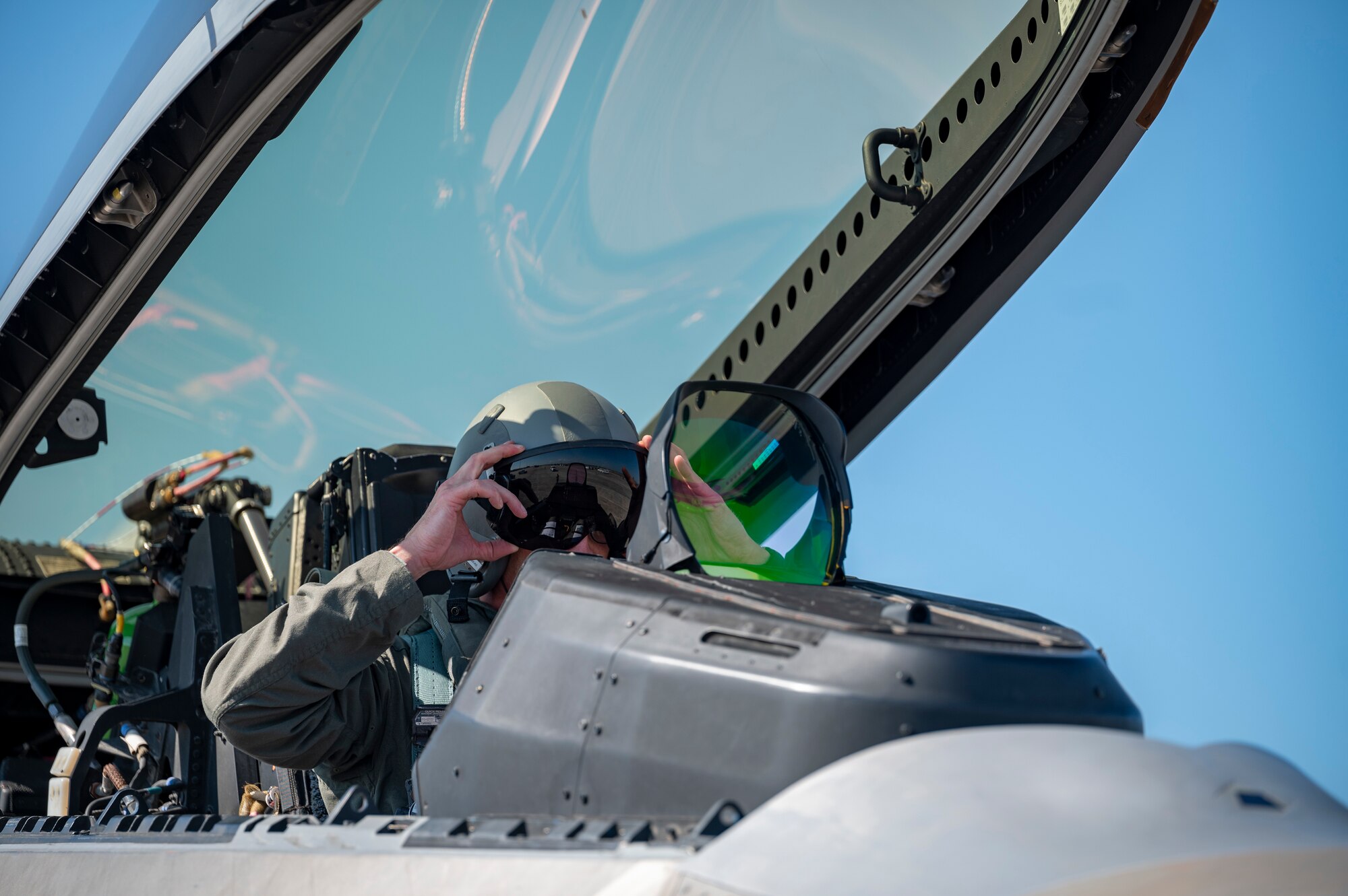 Pilot puts a flight helmet on