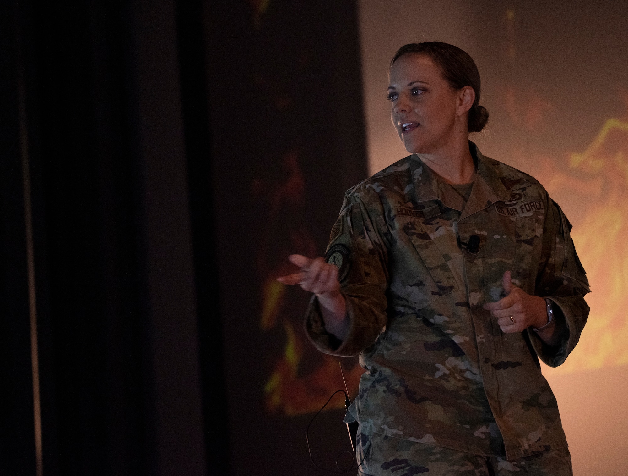 An Airman speaks on a stage.