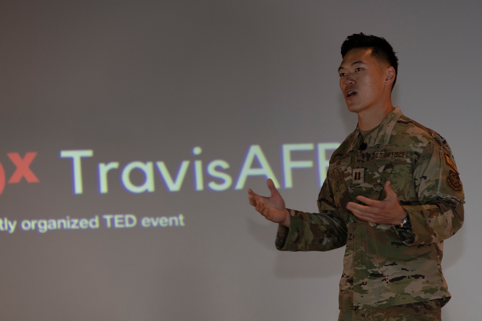 An Airman speaks on a stage.