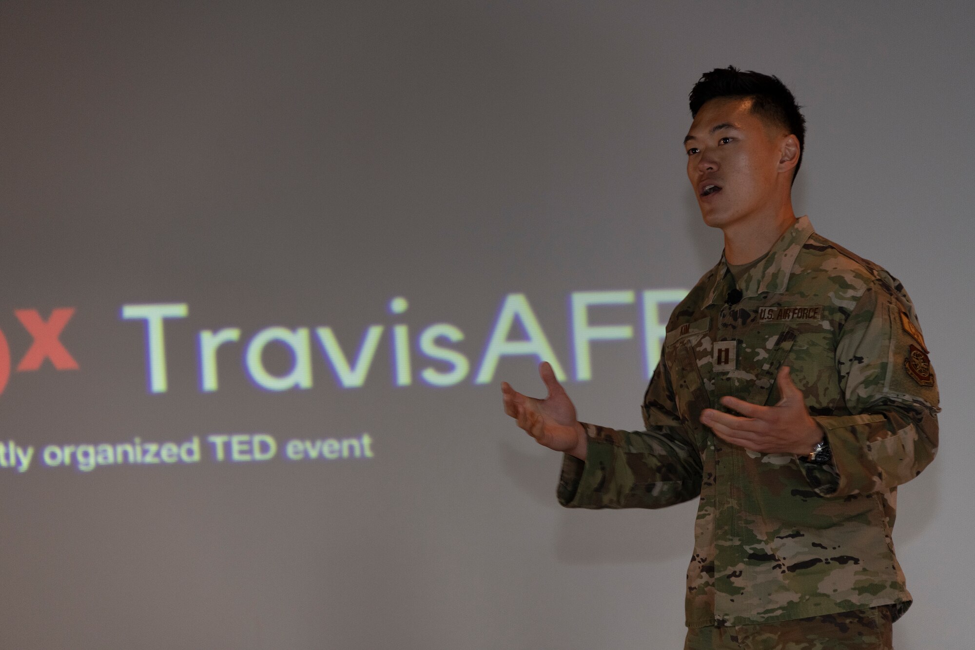 An Airman speaks on a stage.