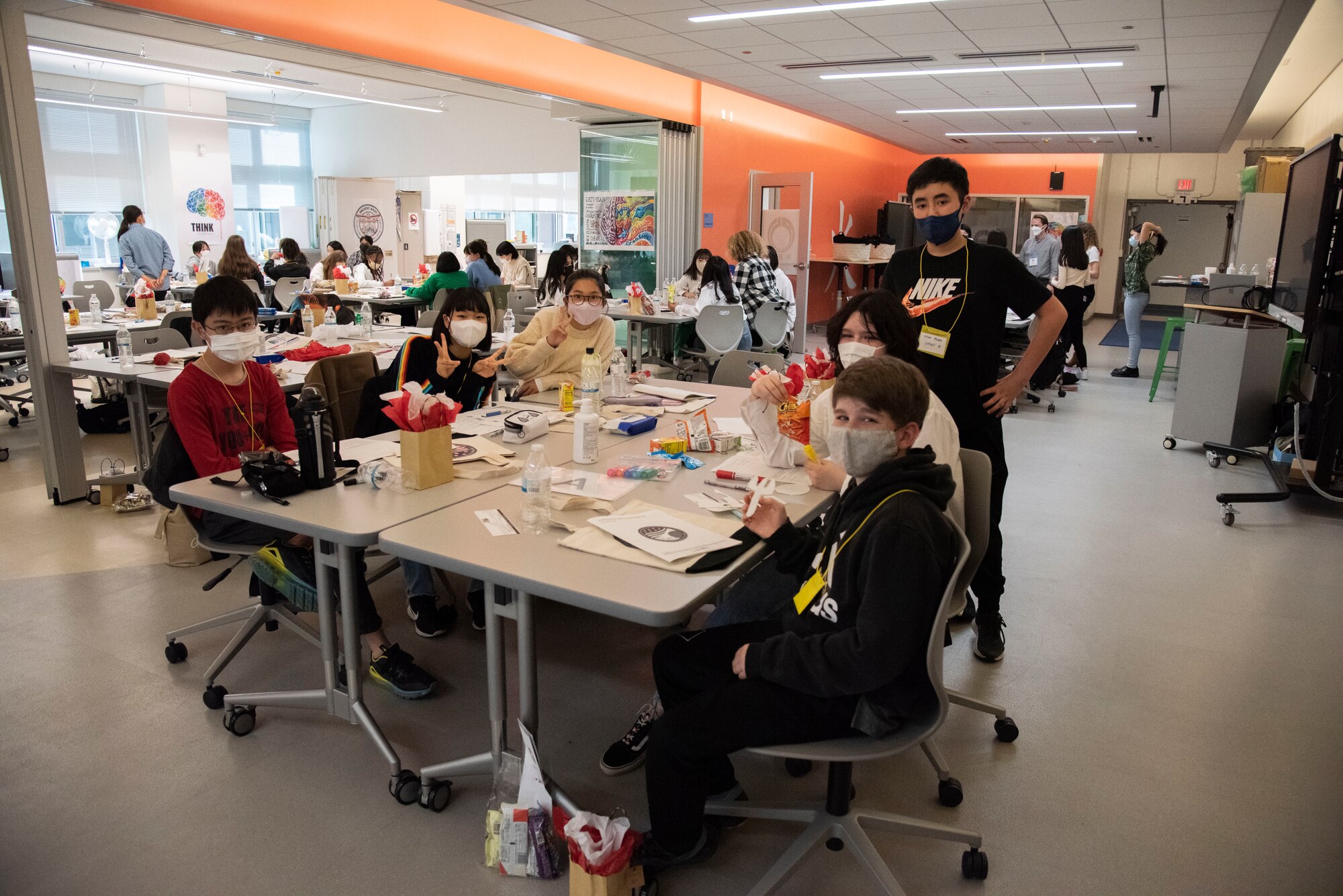 Students pose for a picture surrounding their group's table.