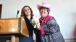 two women stand near a podium