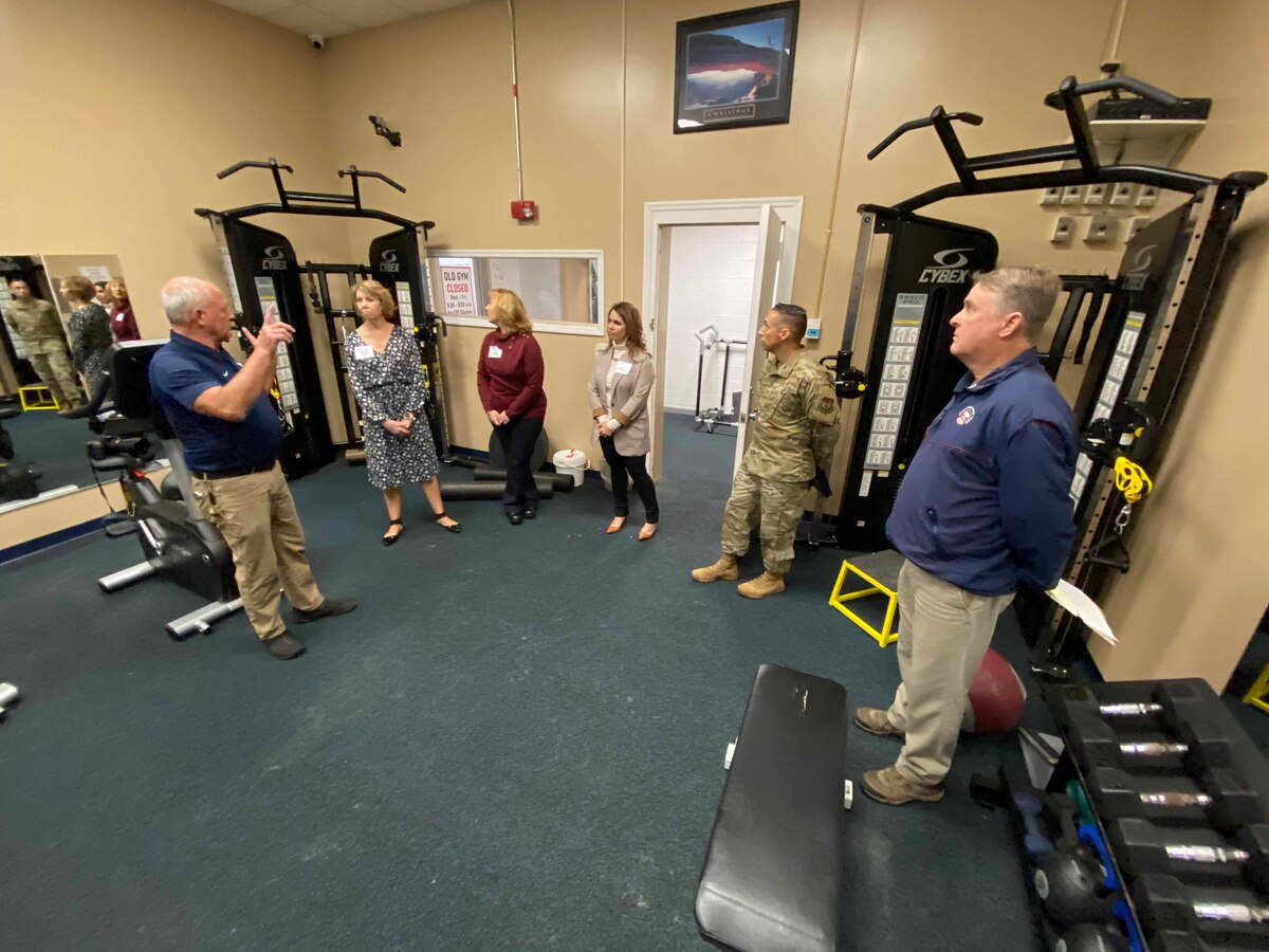 Photo shows group of people in room with fitness equipment