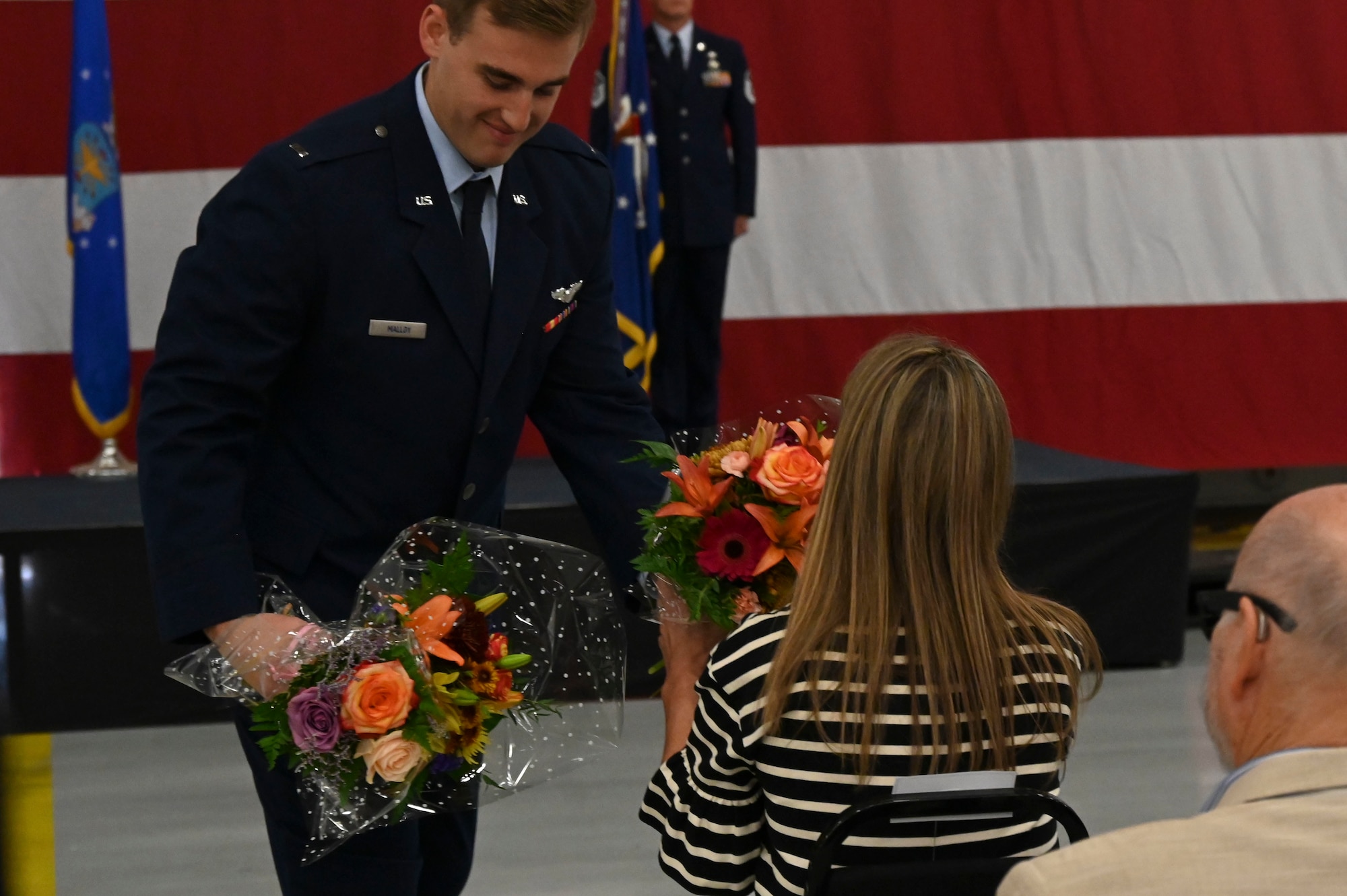 man handing woman flowers