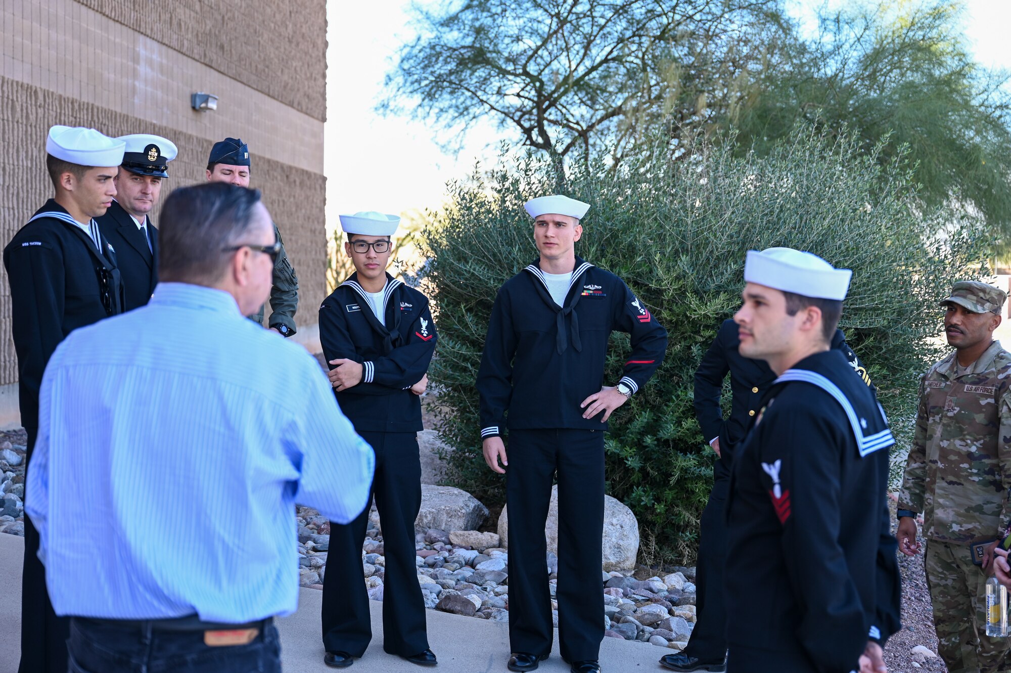A photo of Military members and a civic leader conversing.