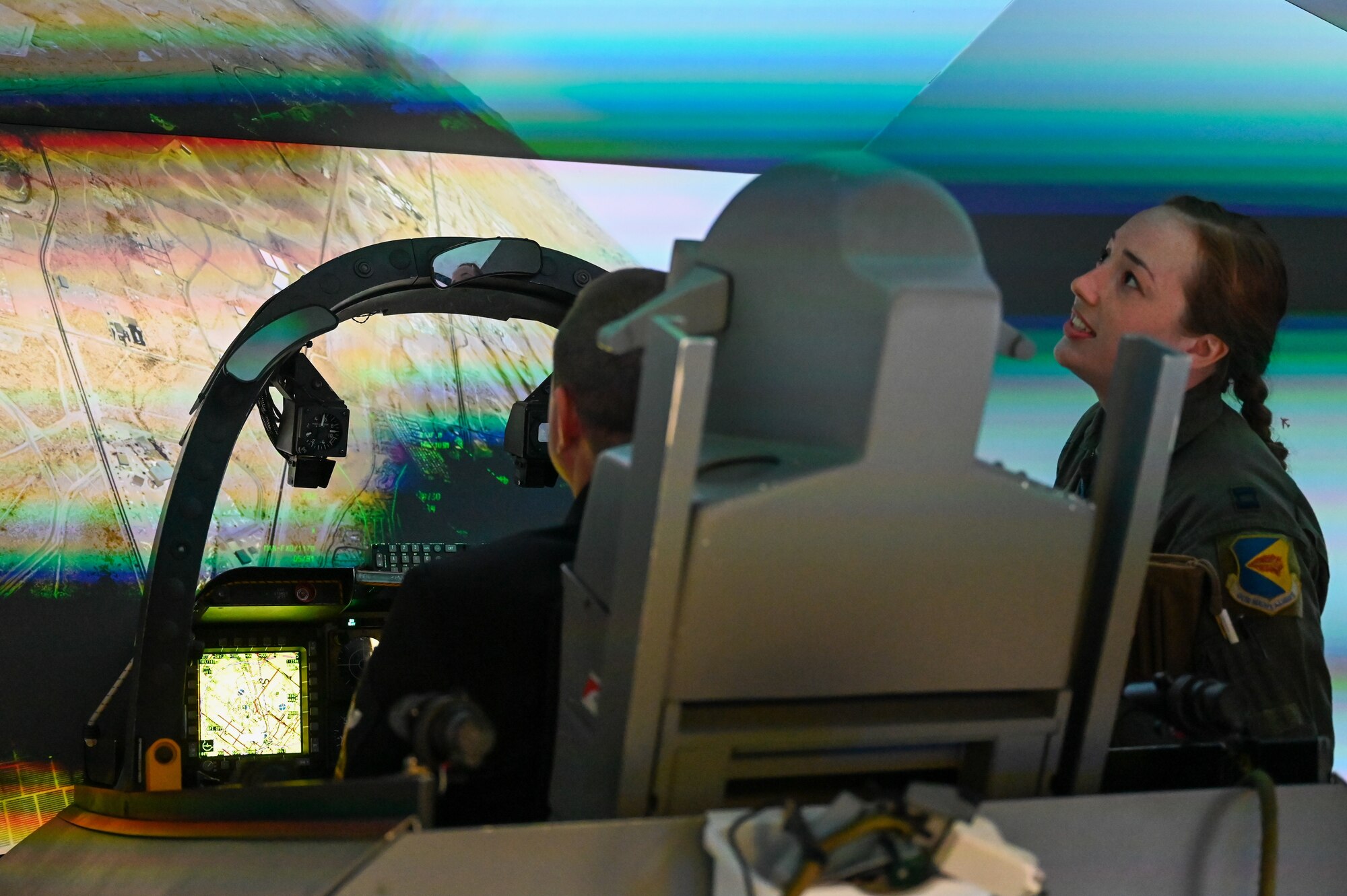 A photo of a pilot and a Seaman in an A-10 simulator.