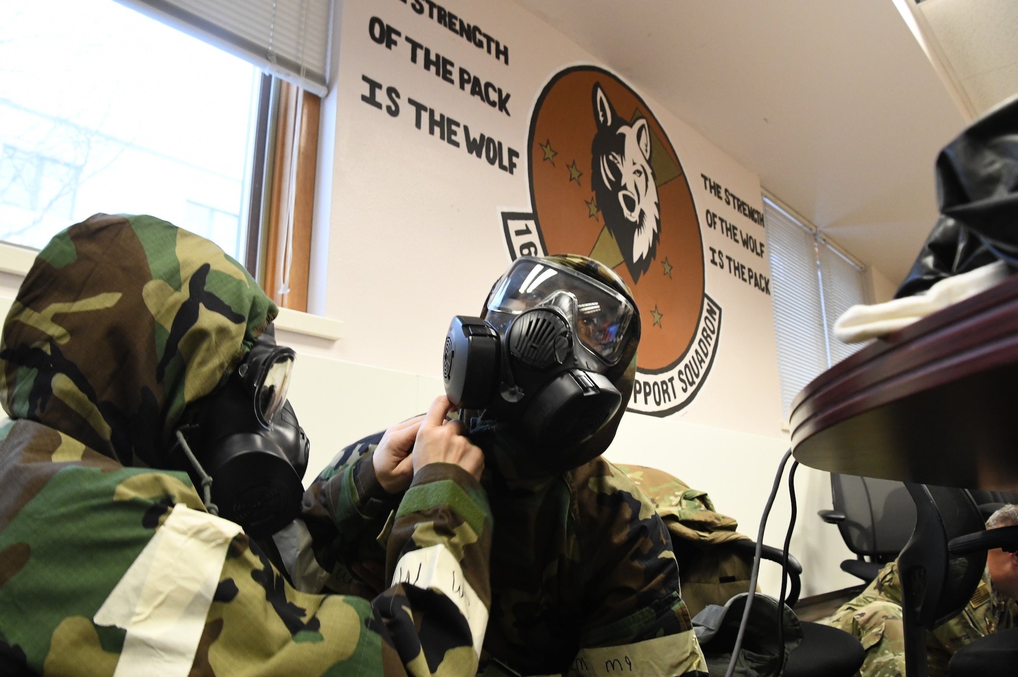 Tech Sgt. Breanna Oswalt, left, and Master Sgt. Quindell Dixon of the 168th Force Support Squadron ensure their Mission-Oriented Protective Posture gear is tightened properly as wingmen during exercise Golden Raven 23-1 at Eielson Air Force Base, Alaska, Nov. 4, 2022. Golden Raven 23-1 was a readiness inspection testing the capabilities to deploy Airmen effectively. (U.S. Air National Guard photo by Senior Master Sgt. Julie Avey)