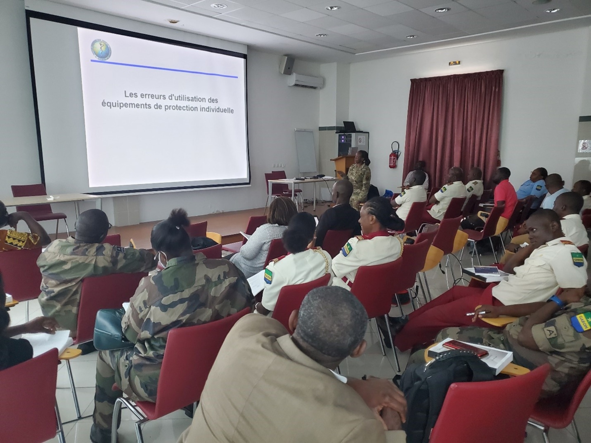 Gabonese military members and civilians sitting in a classroom looking at a screen