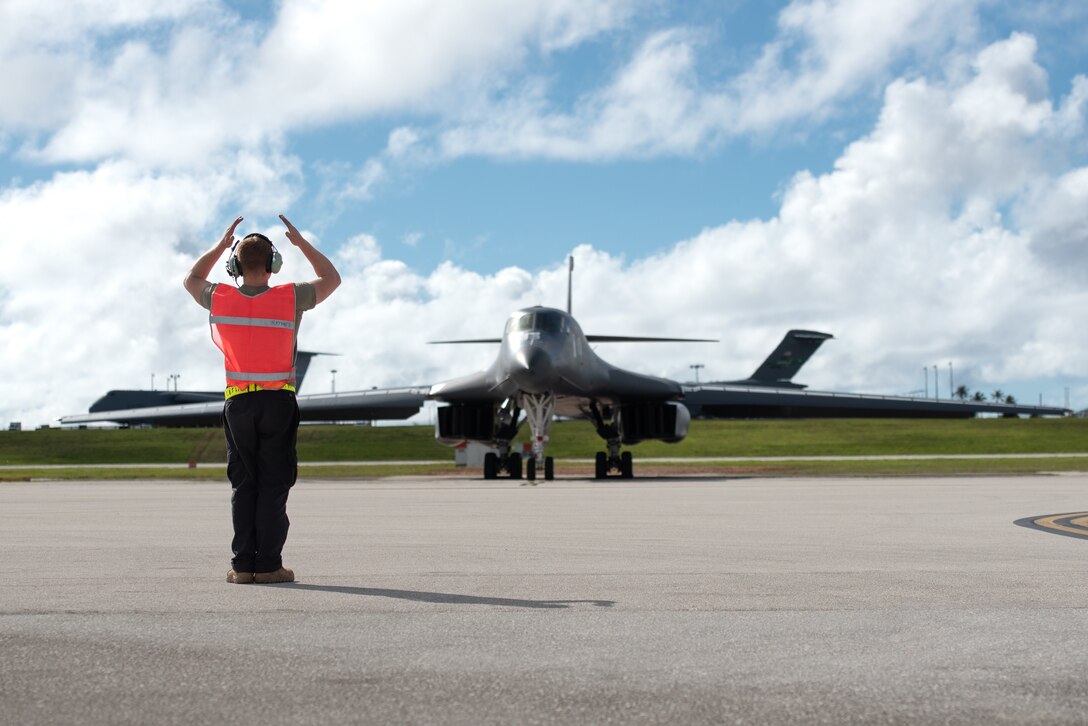 U.S. Air Force Senior Airman Zachary Mette, 28th Aircraft Maintenance Squadron crew chief assigned to Ellsworth Air Force Base, South Dakota, marshals a B-1B Lancer in support of a Bomber Task Force mission at Andersen AFB, Guam, Nov. 7, 2022. The U.S. Indo-Pacific Command routinely and visibly demonstrates commitment to Allies and partners through the employment of military forces, demonstrating strategic predictability while becoming more operationally unpredictable to adversaries. (U.S. Air Force photo by Senior Airman Yosselin Campos)